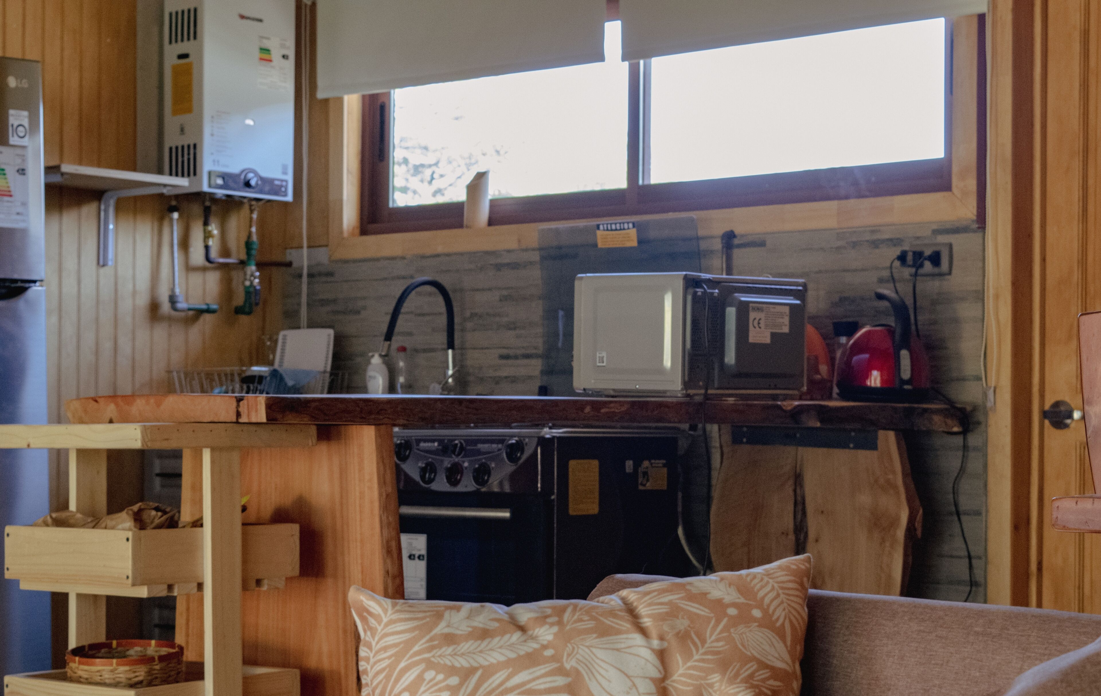 A compact kitchen with a built-in stove, a microwave, and a sink.