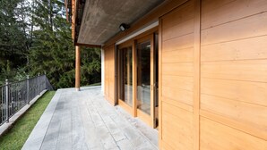 Eine Holzfassade mit Glastür und Betondecke.