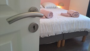 Une chambre à coucher avec un lit, des oreillers et une lampe de chevet.