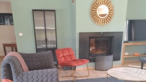 Un salon doté d’une cheminée, d’un téléviseur et de meubles modernes.