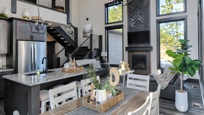 Una cocina moderna con una isla central, electrodomésticos de acero inoxidable y una chimenea.