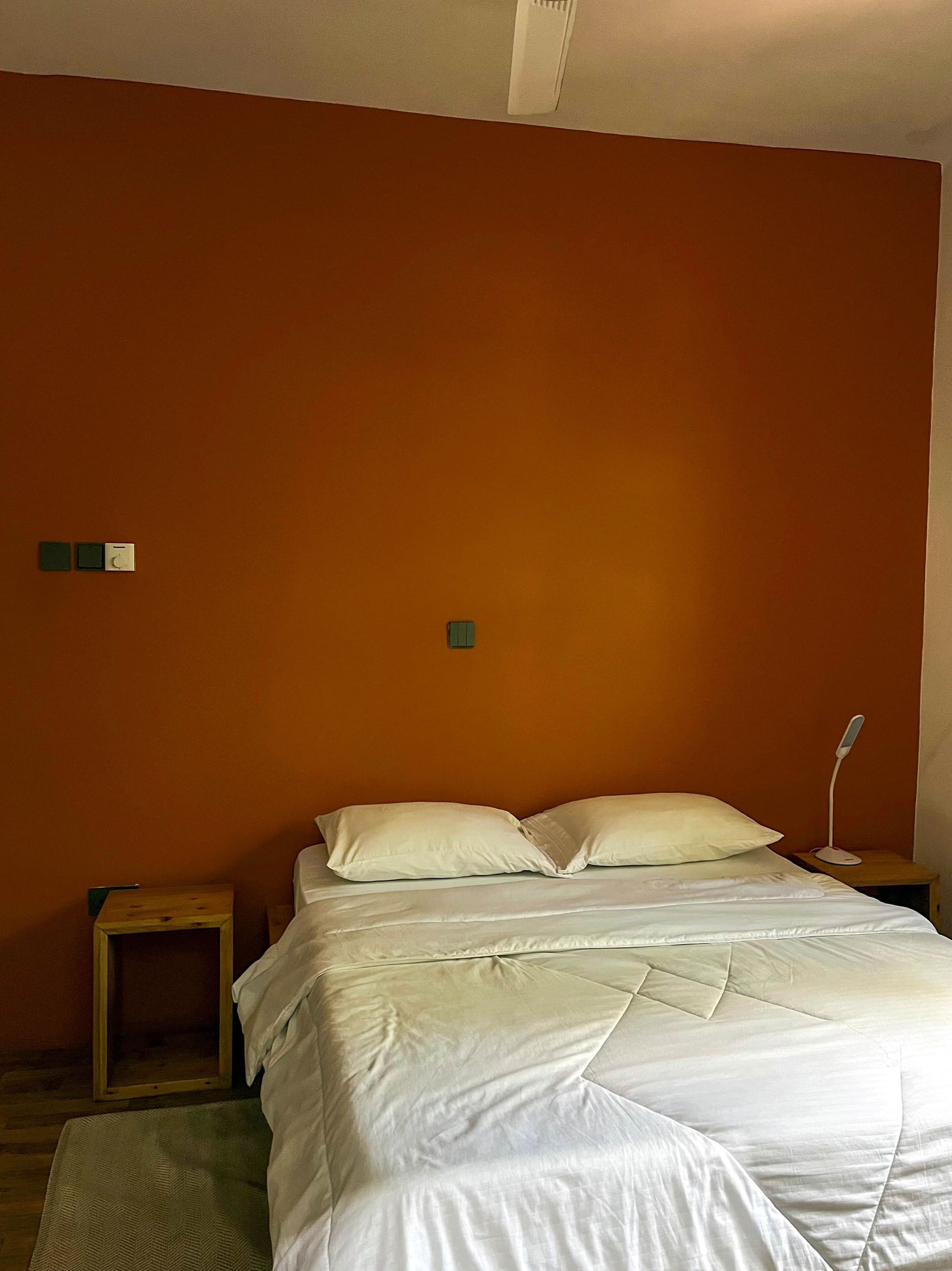 Um quarto com uma cama, uma mesa de cabeceira e um criado-mudo.