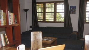 A living room with a sofa, a coffee table, a bookshelf, and a laptop on a table.