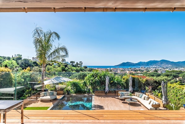 Un área de piscina en la azotea con vistas a la ciudad y a las montañas.