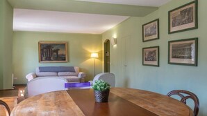 Un coin repas avec une table en bois, des chaises, une petite plante et des tableaux encadrés accrochés au mur.