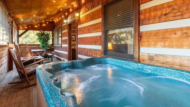 A wooden cabin with a hot tub, wooden deck, and string lights. - 1mi From Parkway ~ Hot Tub ~ Fire Place (Gatlinburg)