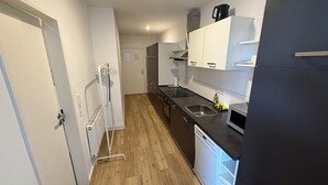 A compact kitchen with a sink, stove, and microwave.