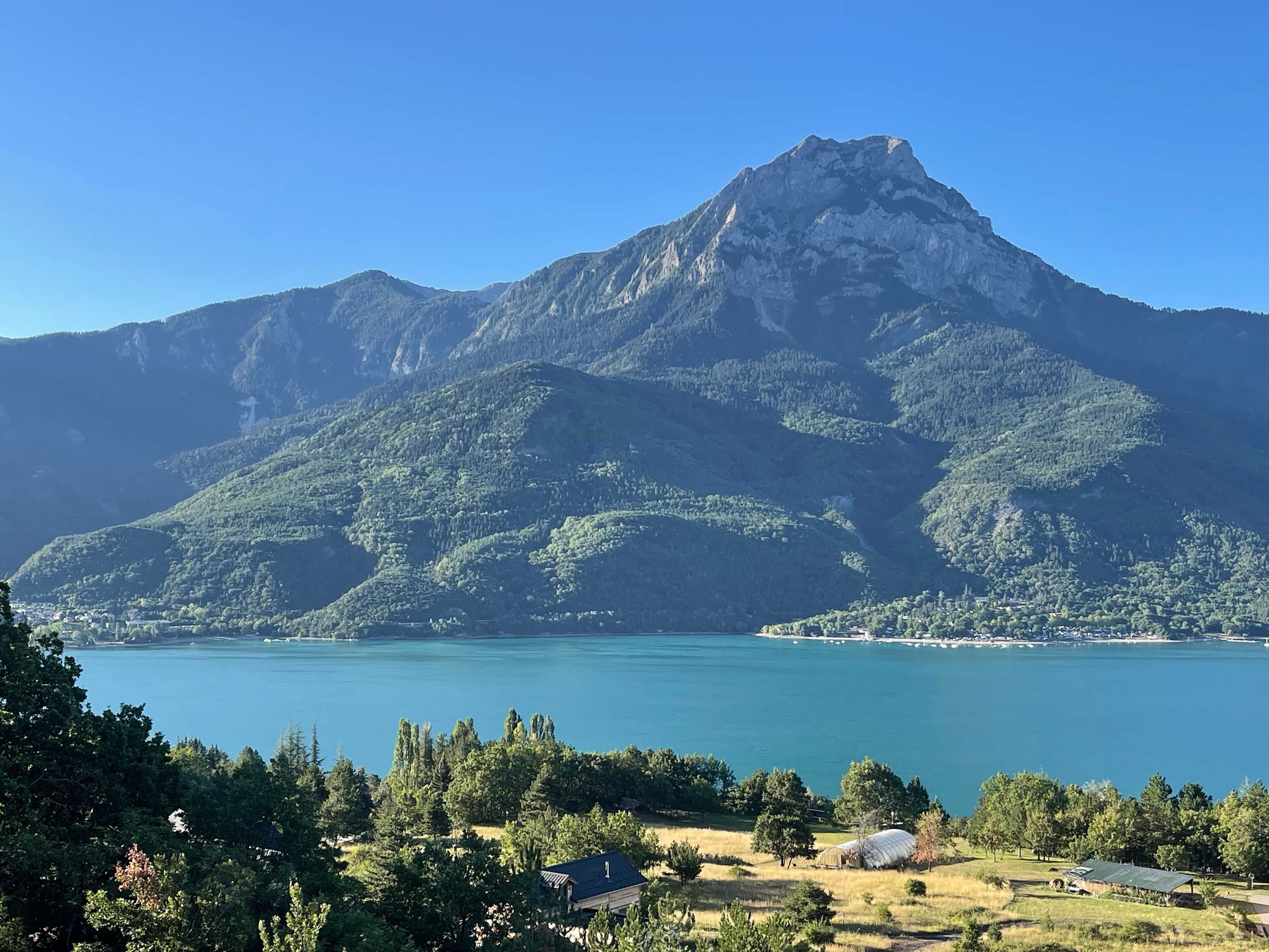 Une montagne avec un lac au premier plan.
