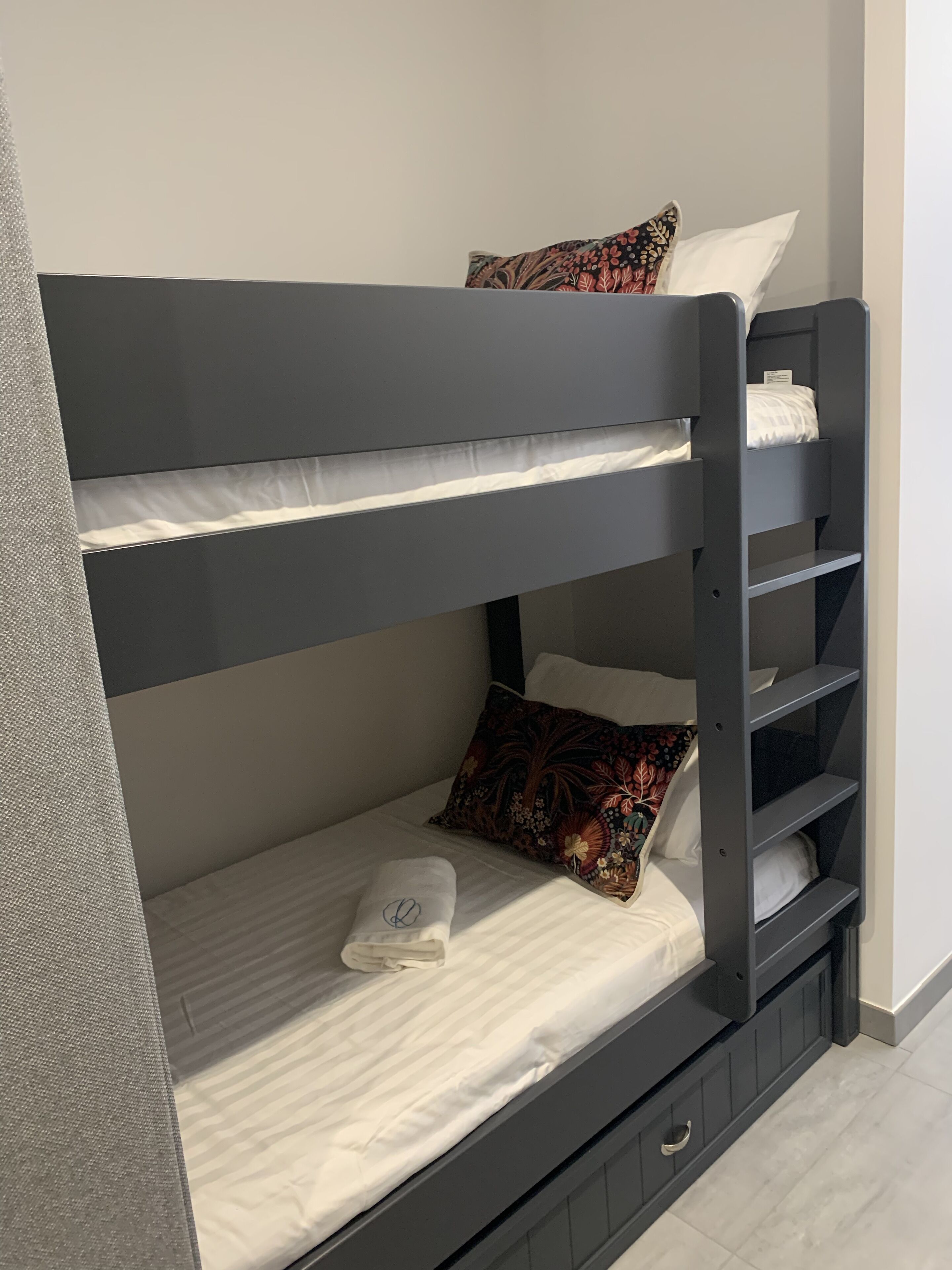 A bunk bed with a pillow and a towel on the lower bunk.