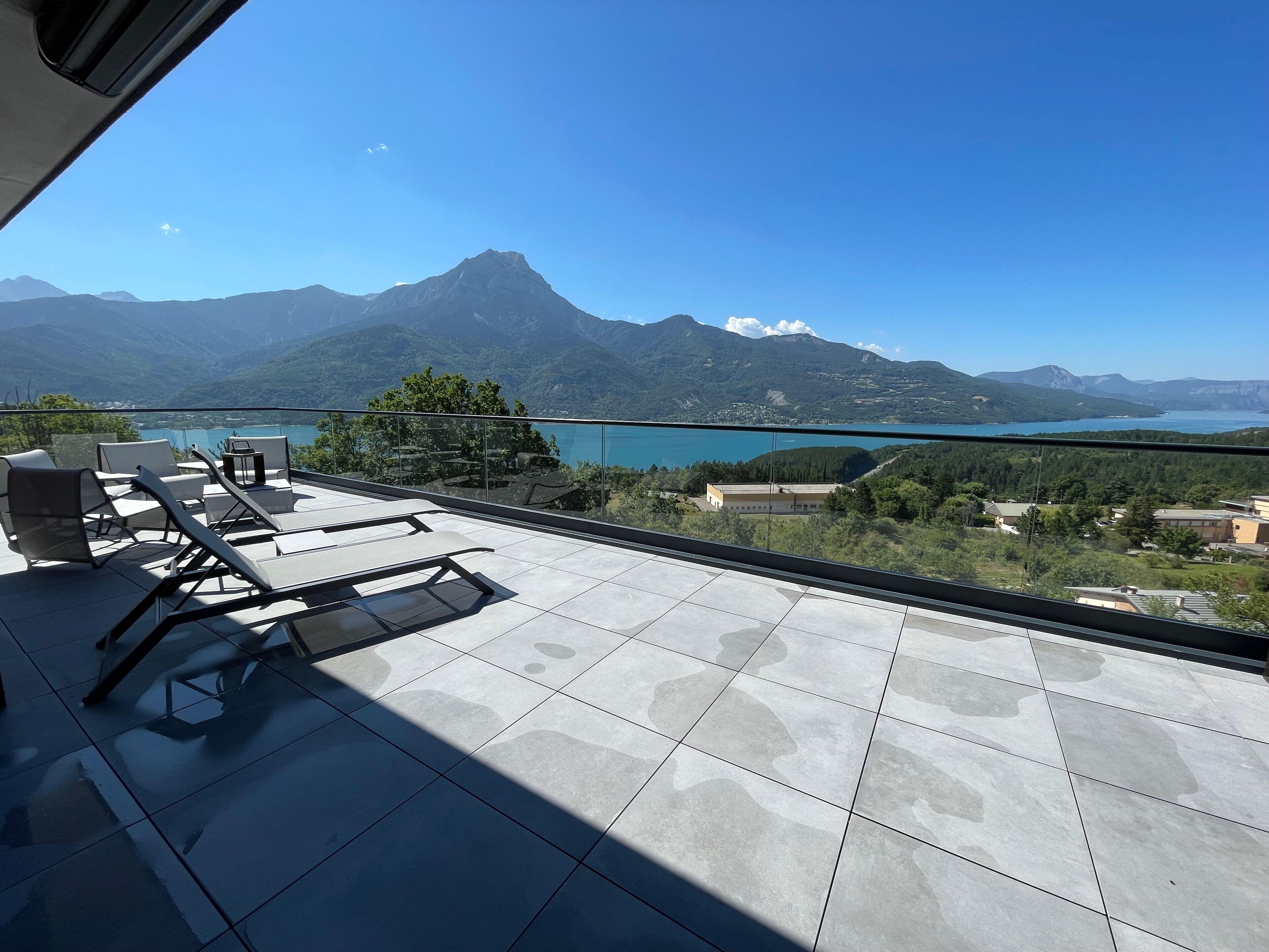 Un balcon avec vue sur les montagnes et un lac.
