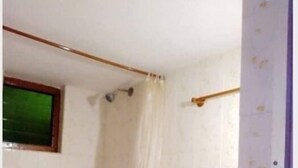 Ein kleines Badezimmer mit Toilette, Waschbecken und Duschvorhang.