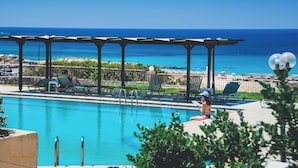 A pool area with lounge chairs and a pergola overlooking the ocean. - Panorama Hotel (Kissamos)