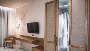 A modern bedroom with a wooden desk, a television, a wardrobe, and a chair. - Panorama Hotel (Kissamos)