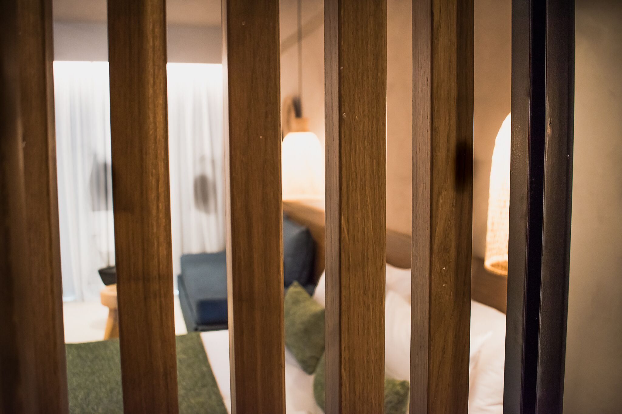 Una habitación con una cama, almohadas y una lámpara.