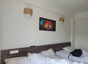A hotel room with two beds, a painting on the wall, and a lamp. - Southern Universal Farm House (Vanur)
