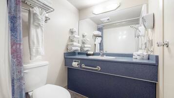 Ein modernes Badezimmer mit Toilette, blauem Waschtisch, Spiegel und Föhn.