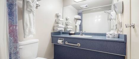 A modern bathroom with a toilet, sink, and towel rack.