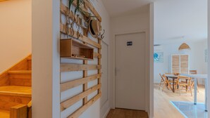 A wooden staircase leading to a room with a wooden shelf and wall-mounted hats. - La Terrasse - Three Bedroom House, Sleeps 6 (La Teste-de-Buch)