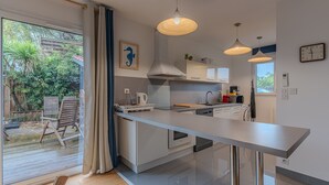 A modern kitchen with a large island, pendant lights, and a view of the backyard. - La Terrasse - Three Bedroom House, Sleeps 6 (La Teste-de-Buch)