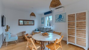 A dining area with a round table, wooden chairs, and a woven ceiling light fixture. - La Terrasse - Three Bedroom House, Sleeps 6 (La Teste-de-Buch)