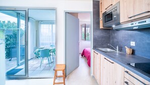 A compact kitchen with wooden cabinets, a microwave, and a sink.