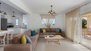 En moderne stue med sofa, sofabord og spiseplads.