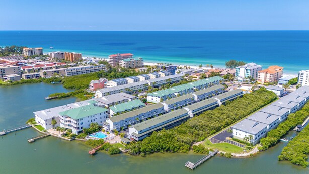 An aerial view of a coastal hotel with multiple buildings, a swimming pool, and a marina. - Relaxing Clearwater-St Pete Beaches!! Clean, beachy and water sports!  (Indian Shores)