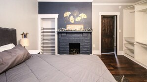 Une chambre à coucher avec un lit, une cheminée, une porte et une armoire.