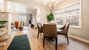 A dining area with a chandelier, a dining table, chairs, and a potted plant. - Cozy Downtown Retreat - Conference Center Home (Salt Lake City)