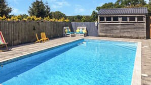 A rectangular swimming pool with a tiled edge, surrounded by a wooden deck. - UK45542-The Farm House (Sampford Courtenay, Okehampton)