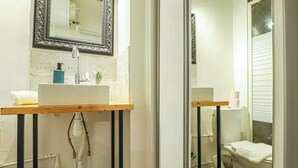 A bathroom with a white sink, mirror, and toilet.