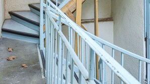 A staircase with a blue handrail and wooden steps leading to a landing.
