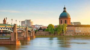 A cityscape with a prominent dome building, a bridge, and a river.
