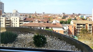 Eine Stadtansicht mit Wohnhäusern und einem markanten Hochhaus im Hintergrund.