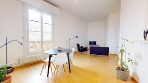 Un espacio habitable amplio con una mesa de comedor, sillas, un sofá y una televisión.