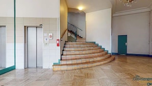 Una escalera con barandilla y una lámpara arriba.