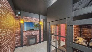 Een kamer met met bakstenen muren, een open haard en uitzicht op de oceaan door een raam.