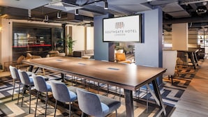 A modern conference room with a long table, several chairs, and a Southgate Hotel London sign. - Southgate Hotel London (London)