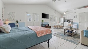 A spacious living area with a large bed, a television, and a kitchenette. - Michigan (Lynn Haven)