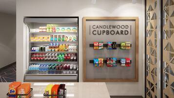 Mostrador de bebidas con una variedad de opciones y un letrero que dice 'CANDLEWOOD CUPBOARD'.