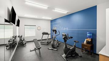 A gym with treadmills, an elliptical, and free weights.