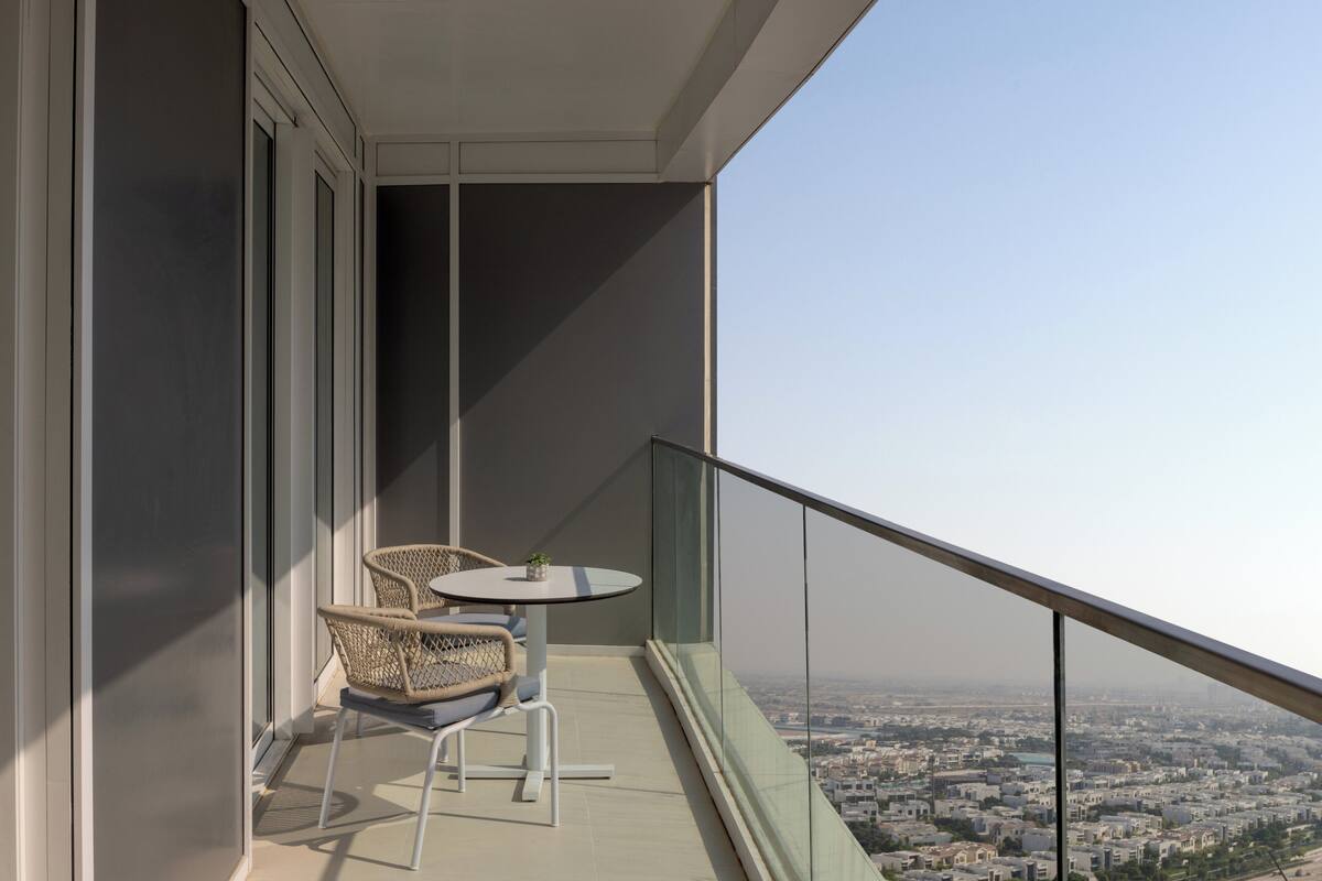 Un balcon avec deux fauteuils en osier et une petite table ronde, d ’où l’on peut admirer la vue sur la ville.