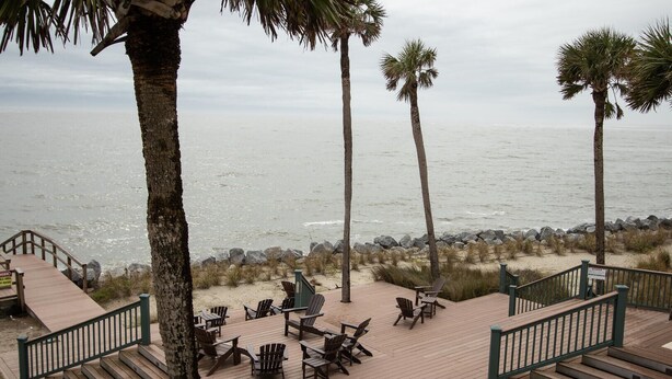 A wooden deck with outdoor seating and a view of the ocean. - 646 New Haven Ct (Fripp Island)
