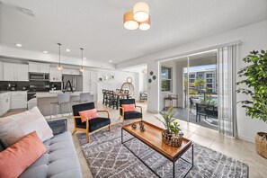 Une cuisine moderne avec des meubles blancs, un four à micro-ondes et un coin repas comprenant une table et des chaises.