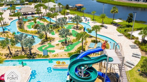 A water park with slides and pools, surrounded by palm trees and a body of water. - 3180-207 Resort Pool View Disney Universal Orlando (Kissimmee)