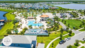 A resort with a central pool, multiple buildings, and a parking area.