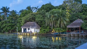 A tranquil lakeside resort with thatched-roof huts, wooden walkways, and lush greenery. - Yayum Bacalar (Bacalar)