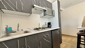 Una cocina moderna con estufa a gas integrada, un lavabo y una cafetera.