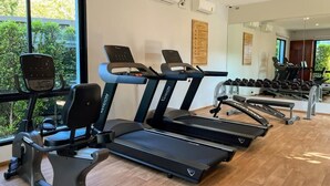 A gym with treadmills, a stationary bike, and dumbbells.