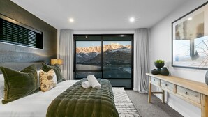 A modern bedroom with a large bed, a view of mountains, and a minimalist design. - Highview Hideaway -  stunning lake and mountain views. (Queenstown)